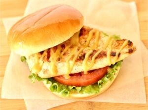 Honey mustard grilled chicken on bun with tomato and lettuce.