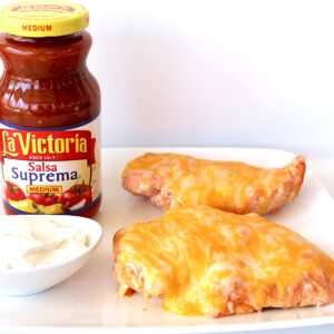 Salsa Chicken with cheese on plate with sour cream to the side.