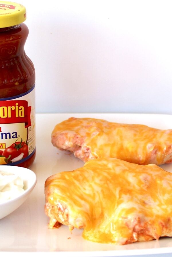 Salsa Chicken with cheese on plate with sour cream to the side.