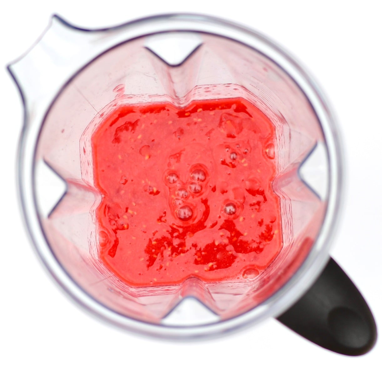 Raspberries being pureed in blender.