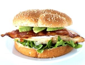 Grilled California chicken sandwich with ranch, bacon, and avocado slices on bun.