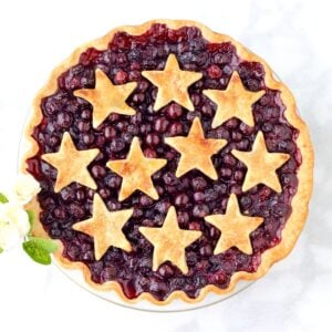 Baked fresh blueberry pie in pie dish with cut out star crust.