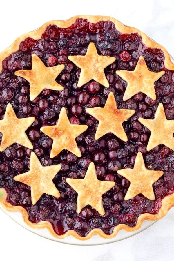 Baked fresh blueberry pie in pie dish with cut out star crust.