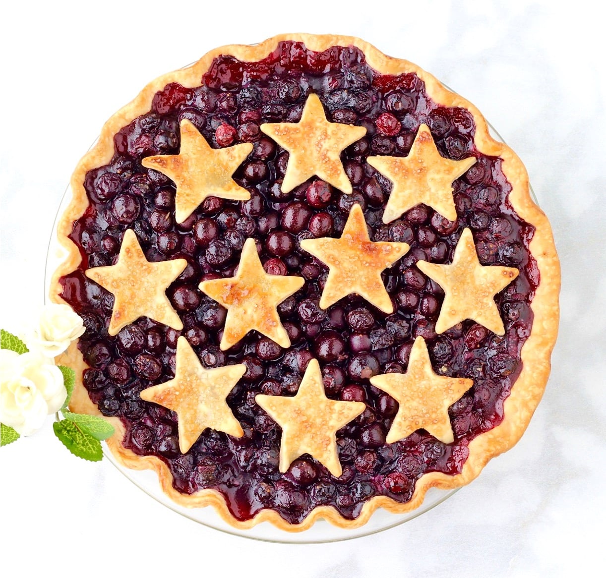 Baked fresh blueberry pie in pie dish with cut out star crust.