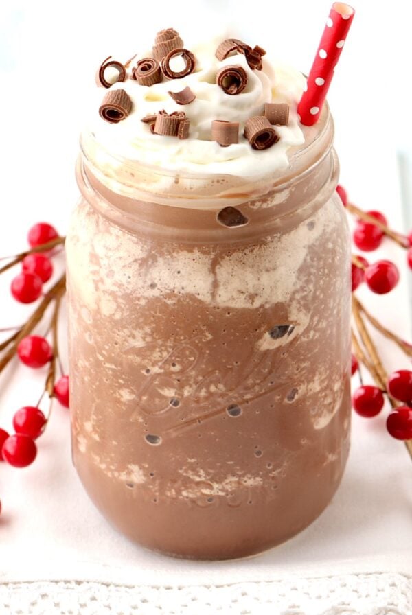Frozen Hot Chocolate in mason jar with whip cream and chocolate curls on top.