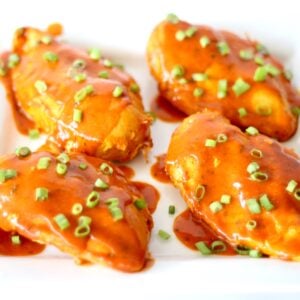 Four pieces of ranch buffalo chicken on plate, garnished with green onions.
