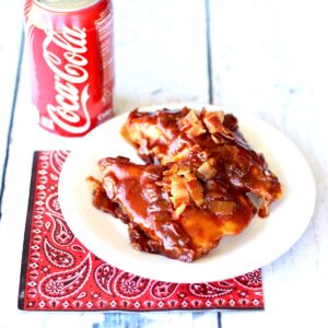 BBQ Chicken on plate with crispy bacon on top.