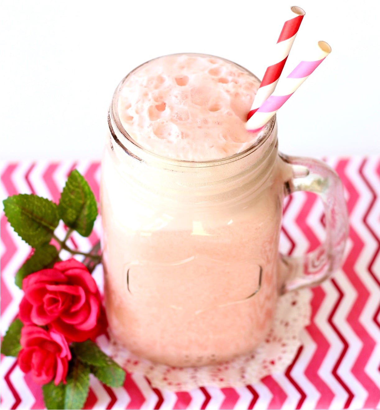 Pink punch in mason jar mug with straws.