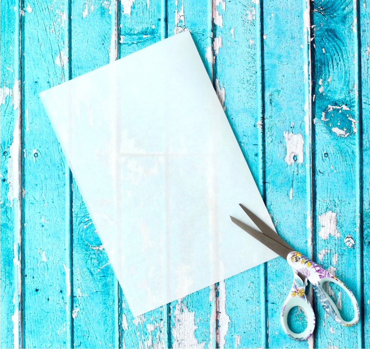 Folded sheet of parchment paper and scissors.