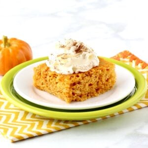 Pumpkin Angel Food Cake on plate with whip cream on top, and pumpkin in background.
