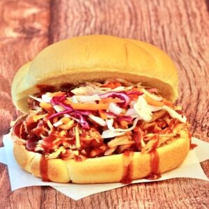 Slow cooker BBQ pulled pork sandwich on bun with coleslaw.