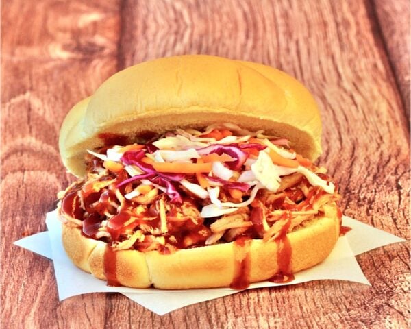 Slow cooker BBQ pulled pork sandwich on bun with coleslaw.