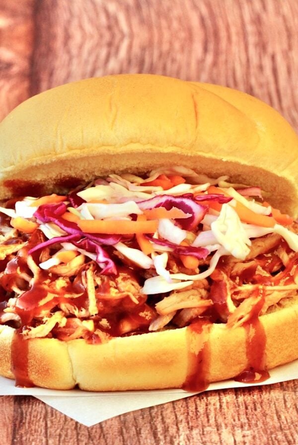 Slow cooker BBQ pulled pork sandwich on bun with coleslaw.