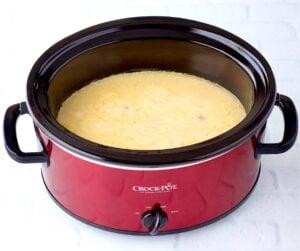 Chicken cooking in crockpot with cream of chicken soup.