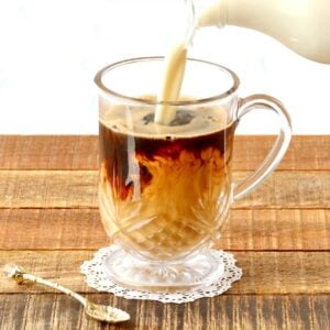 Homemade coffee creamer pouring into mug with coffee.