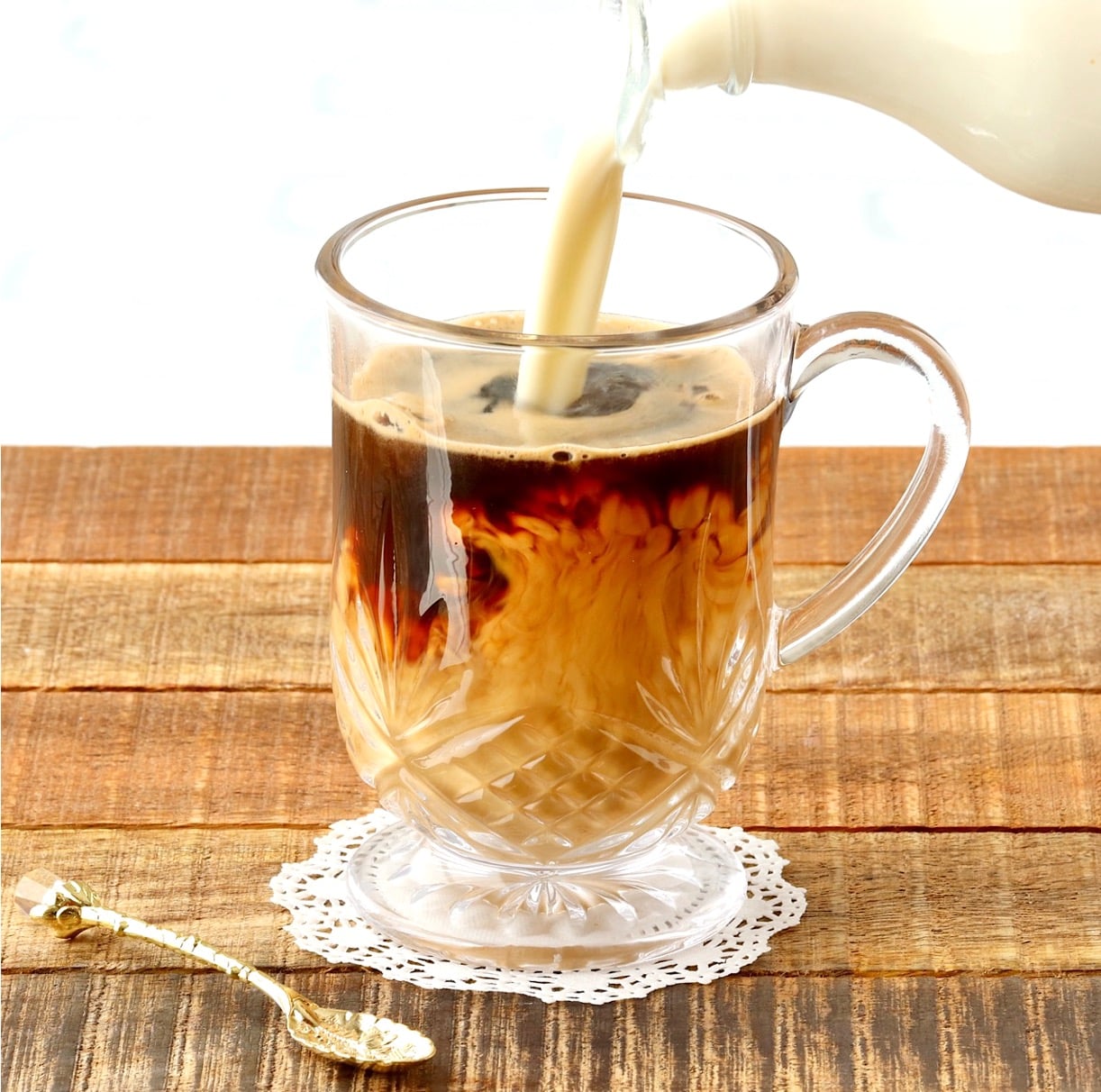Homemade coffee creamer pouring into mug with coffee.