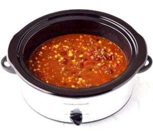 Taco soup with ground beef, beans, and corn in crockpot.