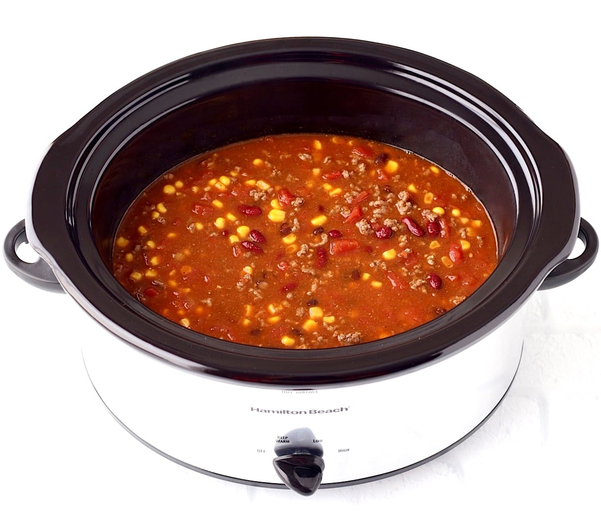 Taco soup with ground beef, beans, and corn in crockpot.