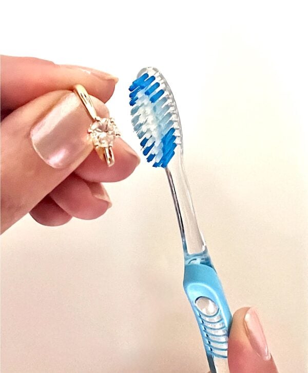 Diamond ring being cleaned with toothbrush.